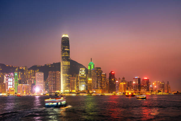 vista di hong kong al crepuscolo con il traghetto, vista da avenue of stars a kowloon. - kowloon bay foto e immagini stock