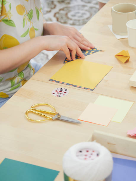 istock hands folding colored paper for make origami figures on a wooden table 1631806164