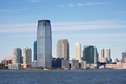 Jersey City skyline shot from Manhattan with Hudson River in foreground.