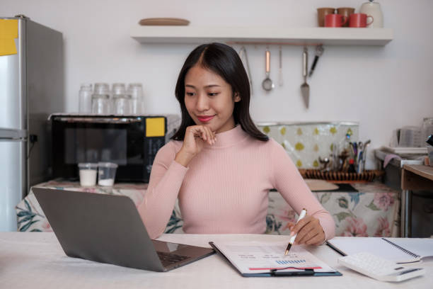 istock Beautiful Young Freelancer Lady Working With Laptop In Kitchen 1631835717