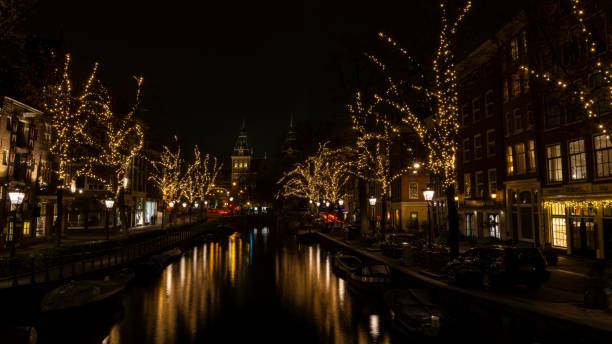 istock a river and lights next to some buildings and trees at night: Amsterdam 1631838859