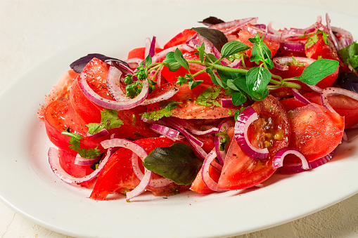 fresh tomato salad, with red onion, spices and herbs, top view, close-up, homemade,