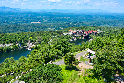 High vantage point view of Mohonk Mountain House in upstate New York with lake and mountains in distance.