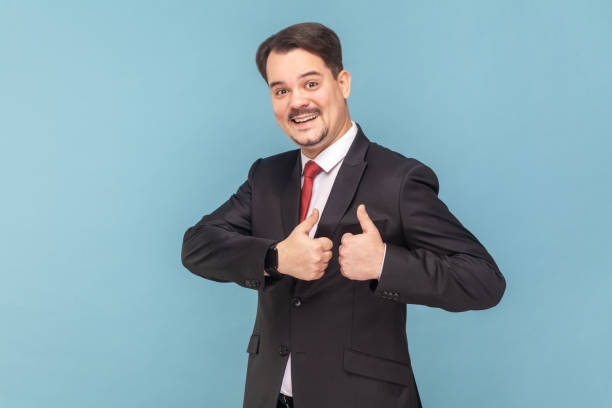 istock Happy satisfied man with mustache standing showing thumb up, recommend service, good feedback. 1631861390