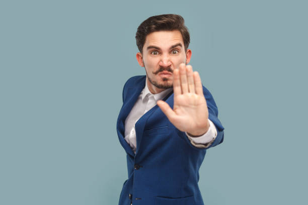 istock Strict bossy man with mustache standing showing palm, stop gesture, expressing negative emotions. 1631861664