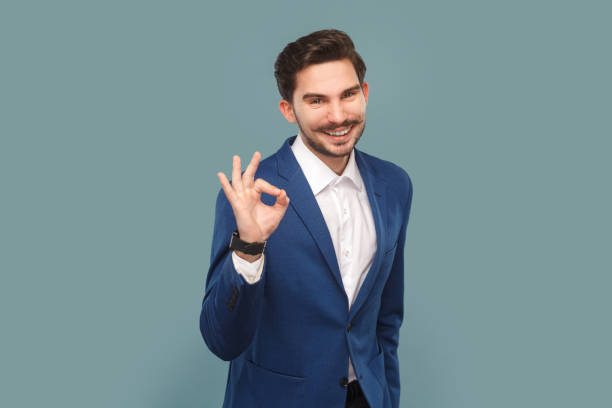 istock Handsome man with mustache showing ok gesture, saying your work is excellent, looking at camera. 1631861668
