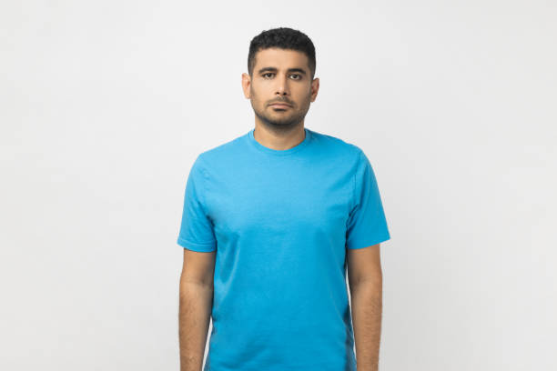 istock Serious srict handsome unshaven man standing looking at camera, having concentrated expressoin. 1631862769