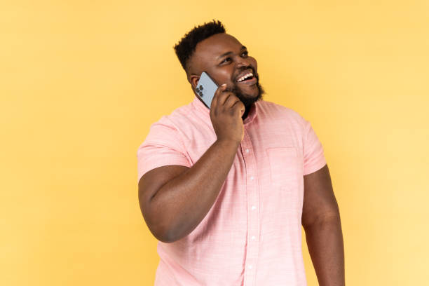 istock Man talking with friend on cell phone looking away and smiling joyfully having pleasant conversation 1631868667