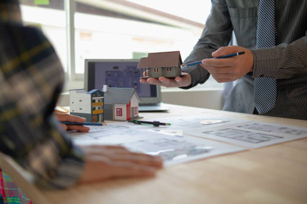 istock Construction engineers discuss and exchange ideas with architects to improve house plans to meet customer needs. A concept for exchange of design ideas between construction engineers and architects. 1631886352