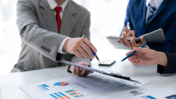 istock Business people together in a meeting using pen pointing at financial data graph in office. 1631887302