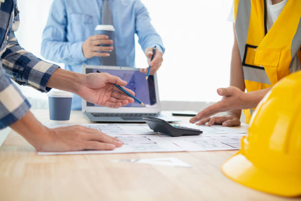 istock Construction engineers discuss and exchange ideas with architects to improve house plans to meet customer needs. A concept for exchange of design ideas between construction engineers and architects. 1631888709