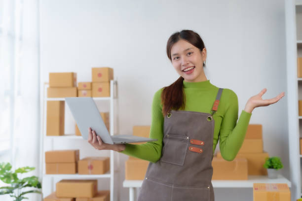Asian businesswoman starting sme. Owner of a small online business SME Distribution warehouse with boxes SME Online Marketing and product packaging and delivery services. Asian businesswoman starting sme. Owner of a small online business SME Distribution warehouse with boxes SME Online Marketing and product packaging and delivery services. newspaper seller stock pictures, royalty-free photos & images