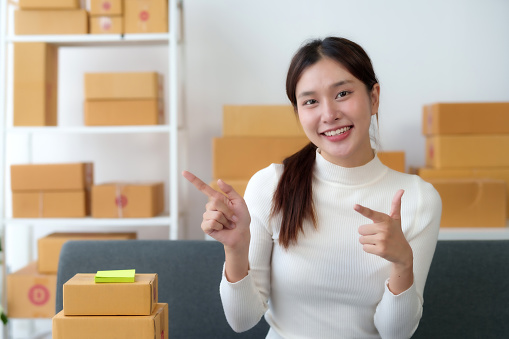Startup happy Asian woman business owner online selling at home office, Startup small business owner working Online selling. SME Online marketing and product packaging and delivery service.