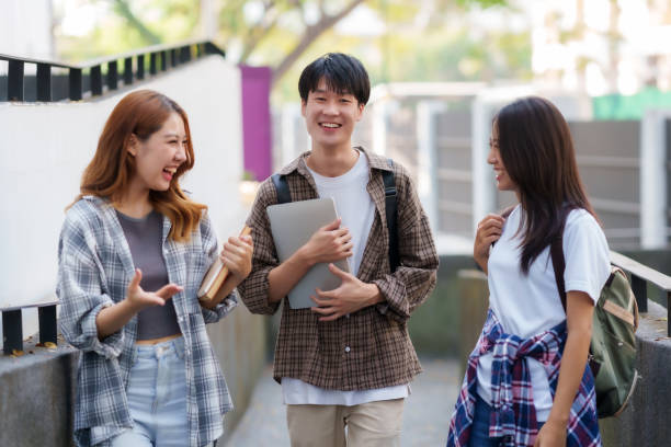 istock Group of Young Asian student walking and talking at university. 1631898885