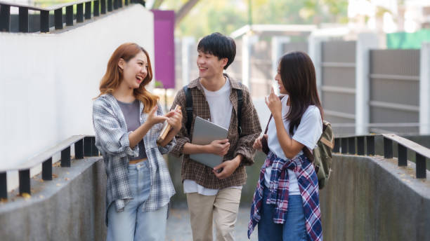 istock Group of Young Asian student walking and talking at university. 1631898889