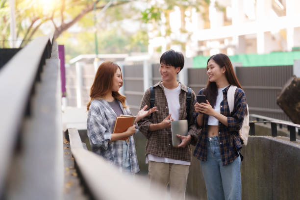 istock Group of Young Asian student walking and talking at university. 1631899179