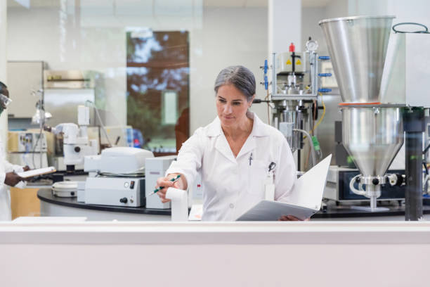 istock Female tech checks readout during experiments in lab 1631902589