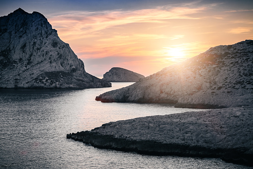 Sunset at Es Vedra, Ibiza Island. Sunbeam with lens flare behind the Isle of Es Vedra, magic rock of Ibiza.