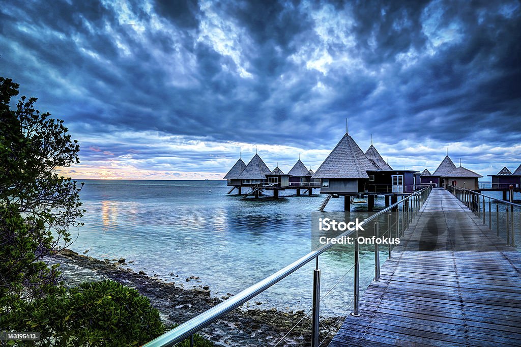 Paraíso Tropical luxuoso Resort ao pôr do sol sobre a água - Foto de stock de Nova Caledônia royalty-free