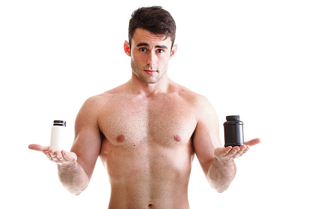 seksowny mężczyzna ciało konstruktora trzyma pudełka z suplementów - creatine nutritional supplement men human muscle zdjęcia i obrazy z banku zdjęć