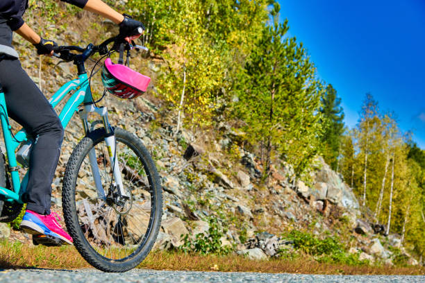 девушка-спортсменка-велосипедистка едет по горной местности, остановилась на боковой дороге - action women beginnings autumn стоковые фото и изображения