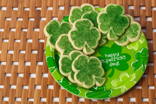 A plateful of colorful green and sprinkles sugar cookies with a plate that says, 