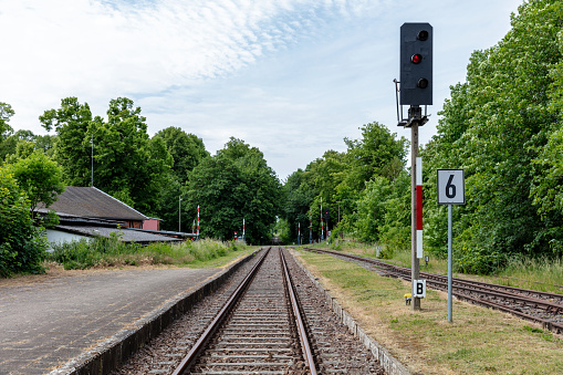 red railway signal at rail track