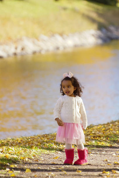 a child stands by a canal in autumn