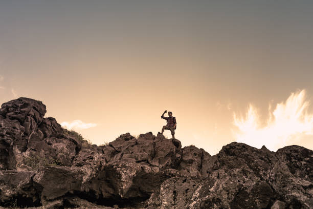 istock Young man hiker getting ready to climb up mountain looking up at the challenge before him. 1632012104