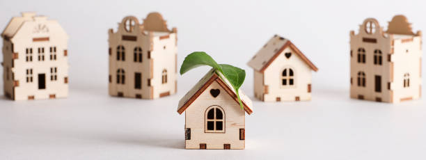 movimiento de modernización, casas a prueba de futuro, carbono neto cero, concepto de adaptación de edificios. casas de juguete con hoja verde en el techo sobre fondo blanco. - retrofitting fotografías e imágenes de stock