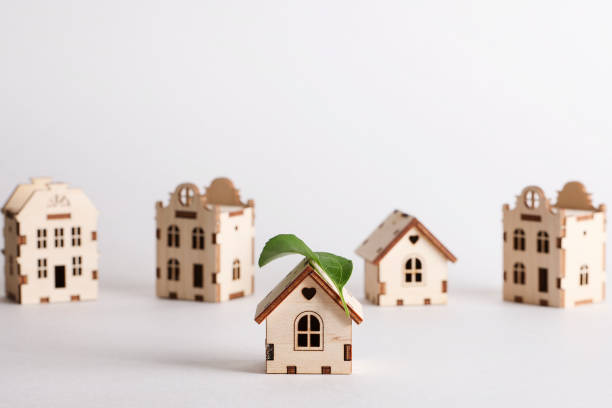 istock retrofit movement, future proofing homes, net zero carbon, adapting buildings concept. toy houses with green leaf on roof on white background. 1632015448