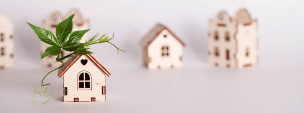 istock retrofit movement, future proofing homes, net zero carbon, adapting buildings concept. toy houses with green leaf on roof on white background. 1632015998