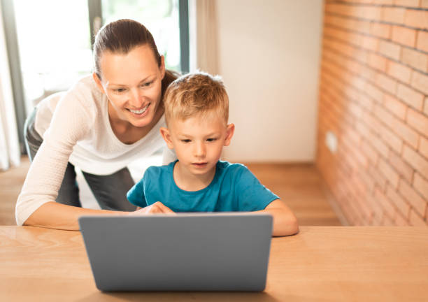 istock Mother helping her son do homework on laptop computer. 1632017086