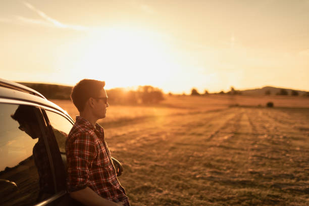 istock Man relaxing by his car and watching beautiful sunset. 1632019781