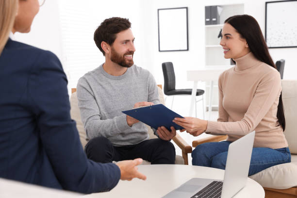 istock Couple signing contract in real estate agent's office 1632027018