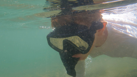 Underwater view of boy snorkelling in river, Crowsnest Pass