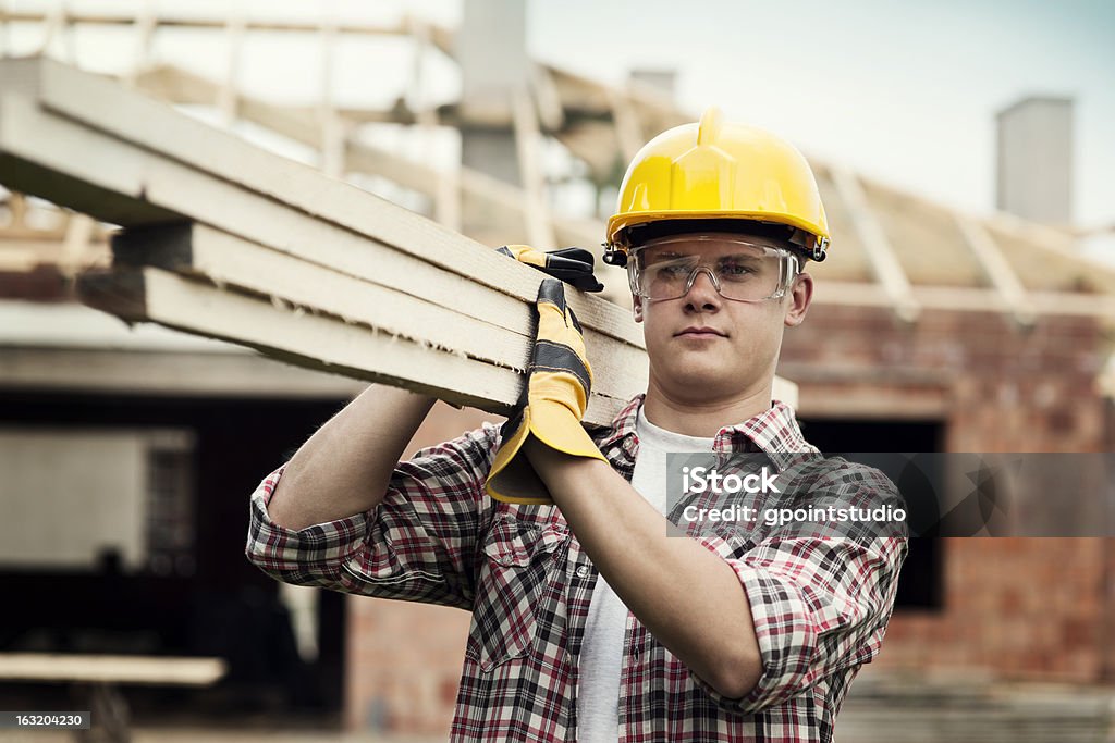 Young construction worker carrying wood boards Construction Worker Construction Worker Stock Photo