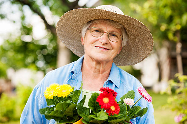 istock Senior woman with flowers 163204399