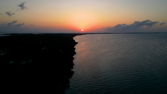Sun sets over calm bay and island, Eleuthera