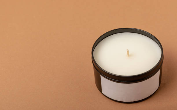 istock Soy candle in a black candlestick on a brown background. Space for text. Decor. 1632055770