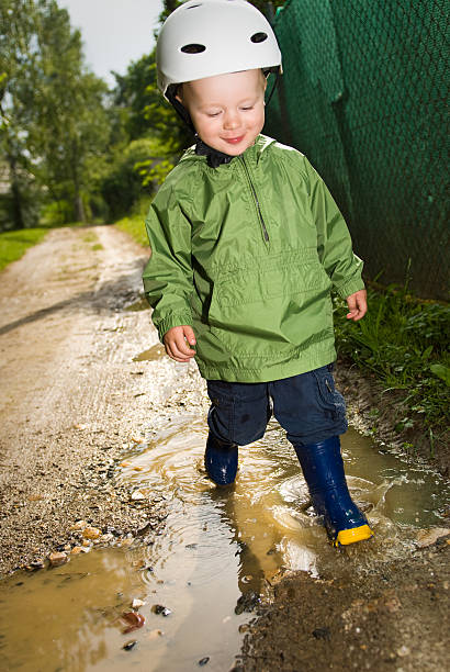 Boy has fun by running in puddles stock photo