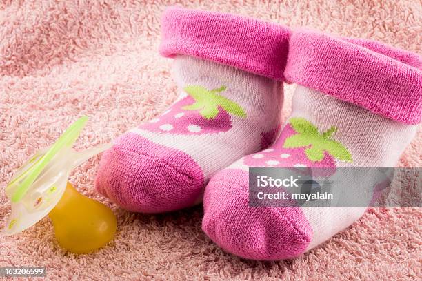 Pacifier And Little Pink Socks Stock Photo - Download Image Now - Rubber - Material, Sock, Child