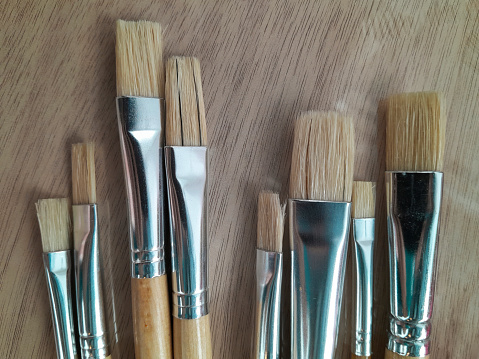 Row of artist paintbrushes closeup on canvas