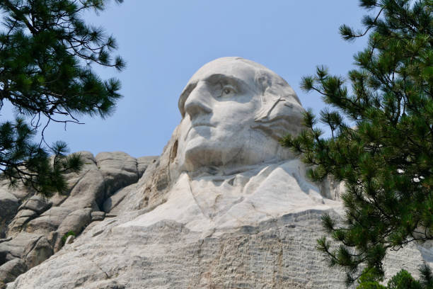A vertical shot of Washington memorial at Mount Rushmore against blue cloudy sky