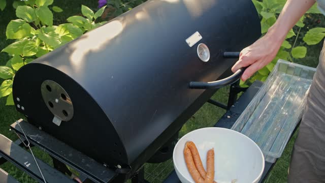 Caucasian Man Operating Garden Party Charcoal Grill Preparing Tasty Sausages