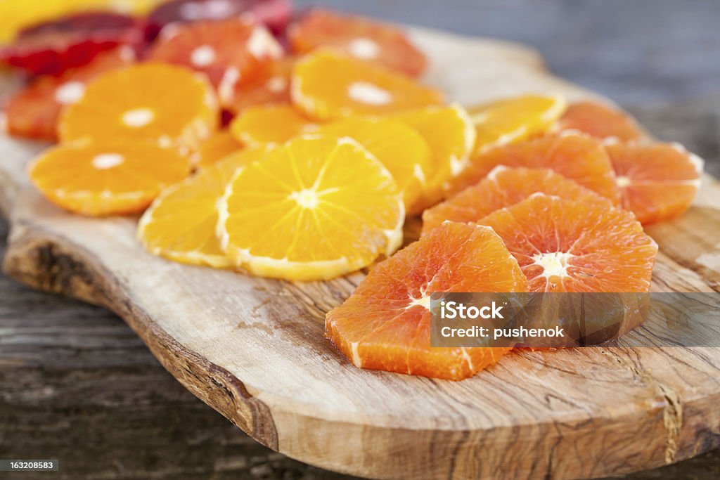 Rebanadas de frutas frescas, jugosas naranjas en tabla de cortar. - Foto de stock de Alimento libre de derechos
