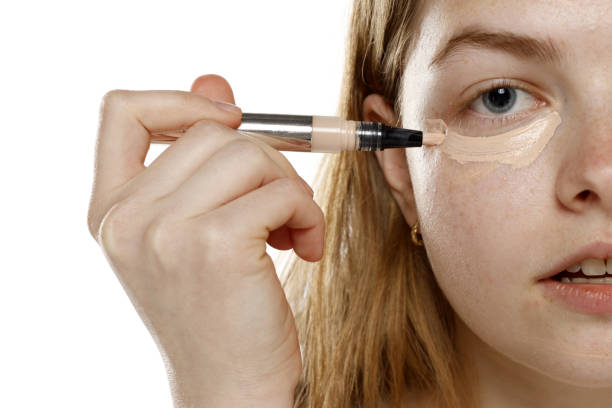 istock young blond woman apply concealer under the eye on a white background 1632090817