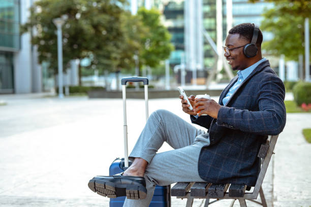 istock Young African American man using wireless technology on a business trip 1632095725