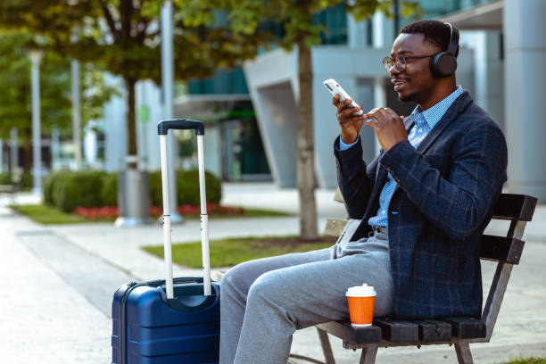 istock Young African American man using wireless technology on a business trip 1632098932