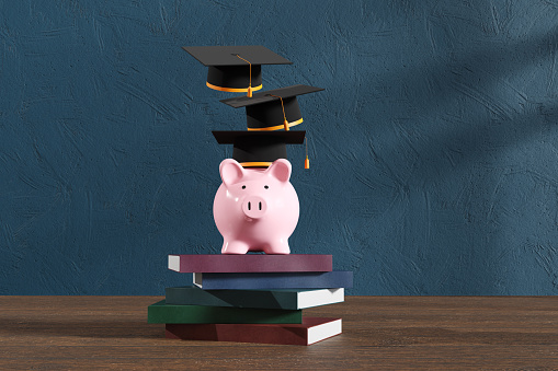 Pink piggy bank wearing mortar boards standing on a stack of hardcover books. Illustration of the concept of investing and funding for children's education